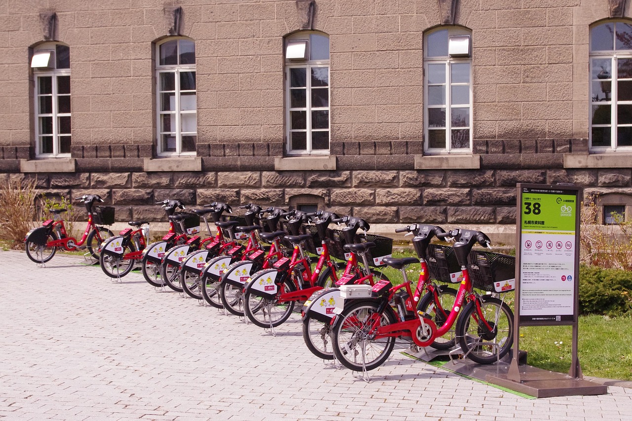 Rząd rowerów miejskich dostępnych do wypożyczenia ustawionych przy stacji rowerowej